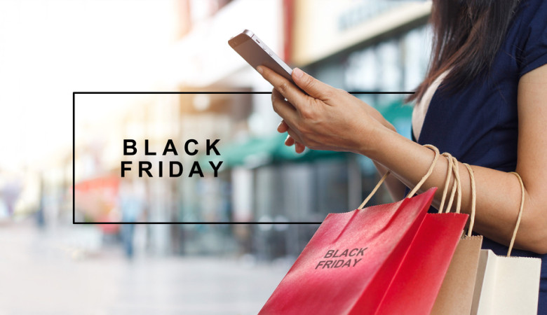 Black,Friday,,Woman,Using,Smartphone,And,Holding,Shopping,Bag,While