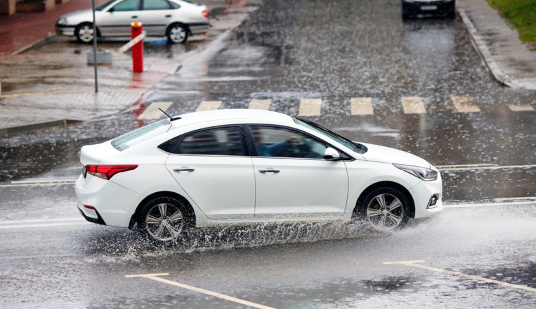 White,Car,Driving,Fast,On,Wet,City,Road,During,Rain,